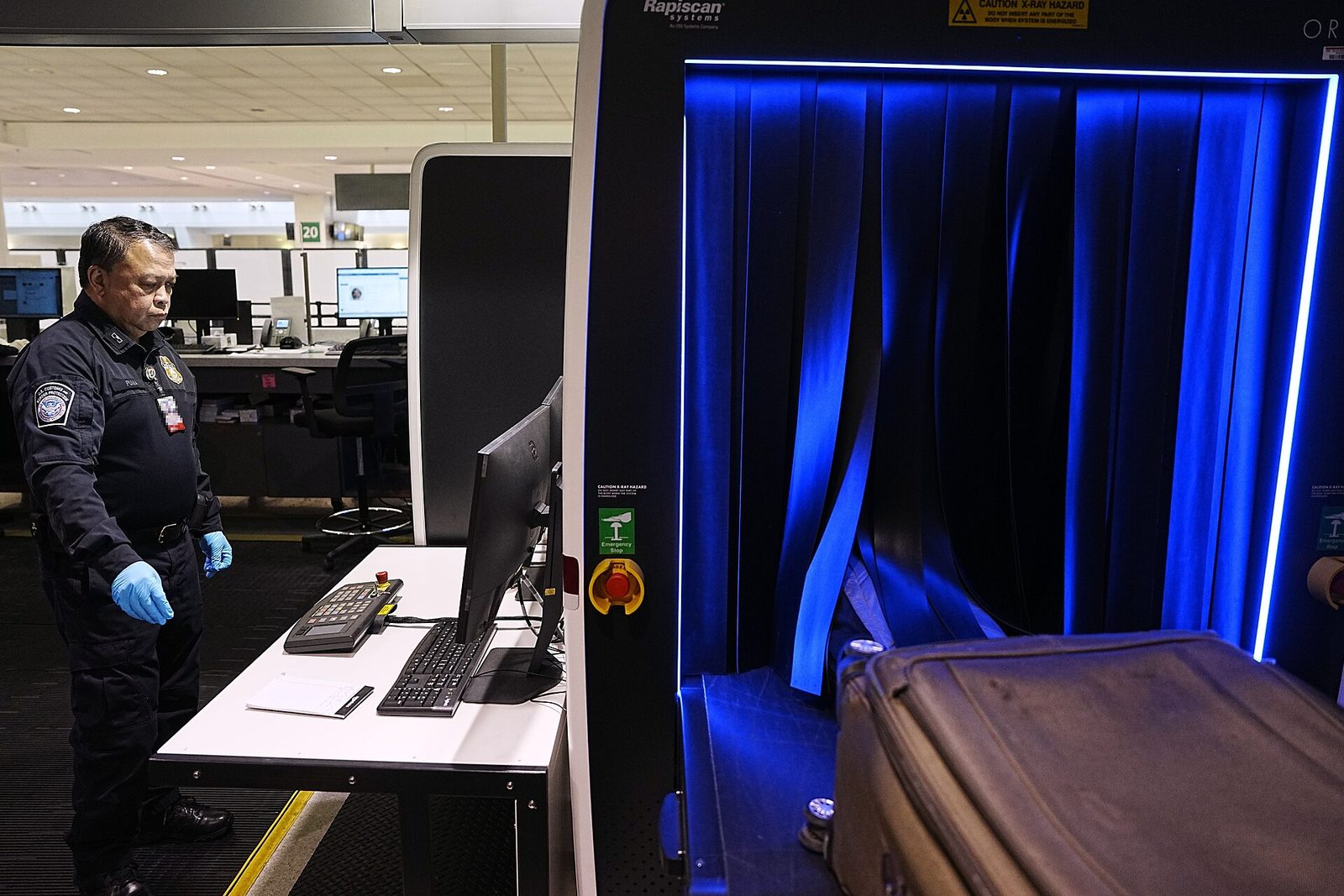 Arriving passengers' luggage under inspection (customs X-ray screening)