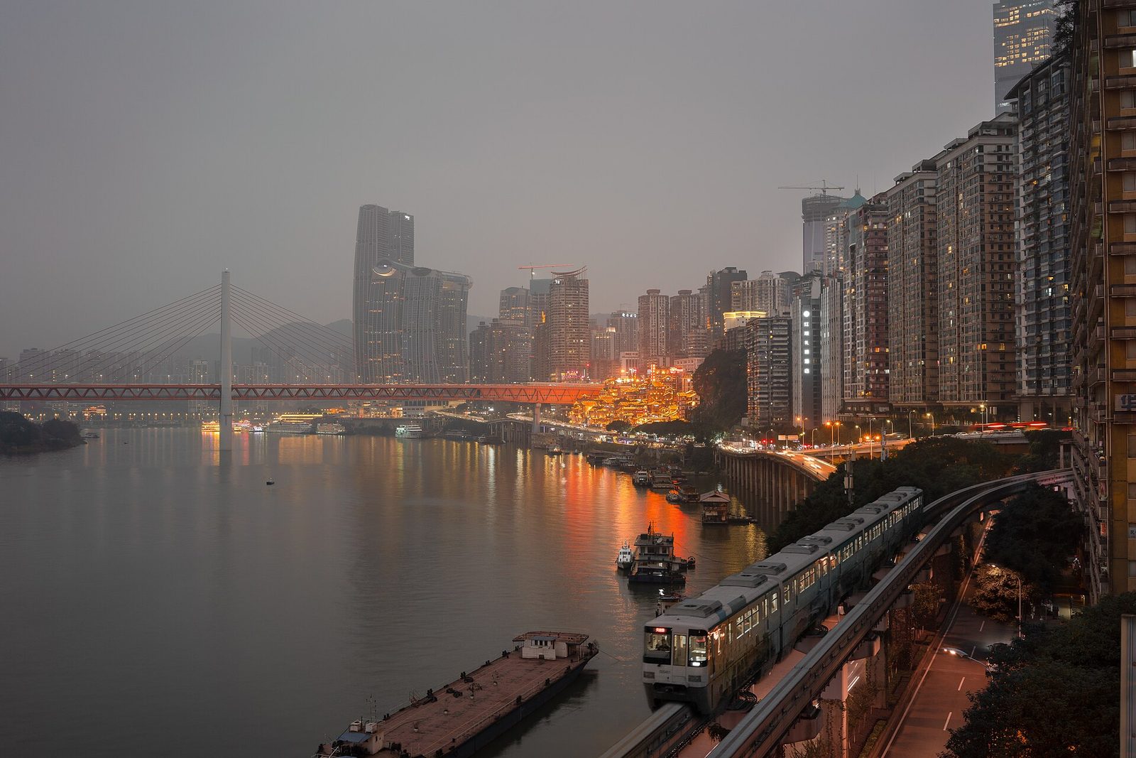 Night view of the Yuzhong Peninsula with a monorail train gliding overhead